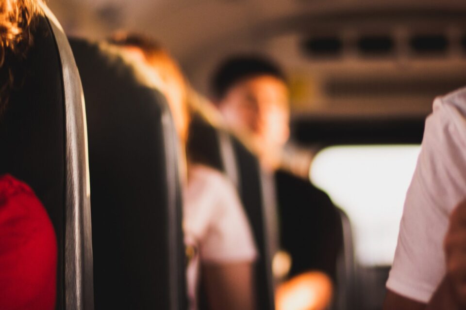 woman in red shirt sitting on bus seat